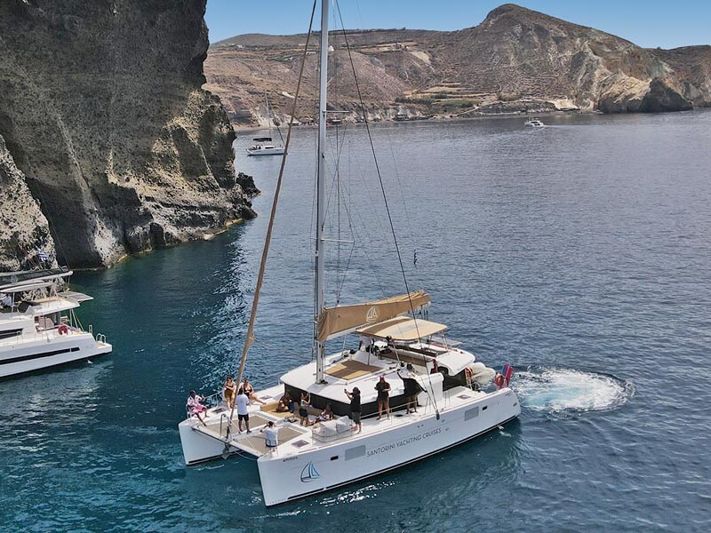 catamaran anchored by the caldera Santorini - Charter Cruise