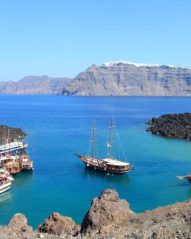 Port of Santorini volcanic island Kameni, with tour boats in small harbour